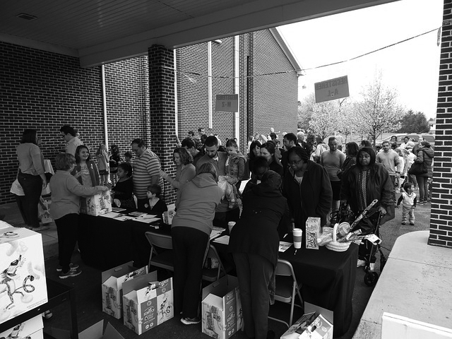 grayscale photo of people at a crowded event for donations
